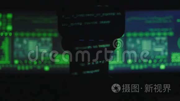 黑客程序员的剪影使用虚拟现实头盔进行编程，而绿色代码字符则反映他的情况