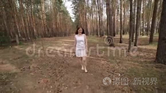 一个穿白衣服的女孩正在树林里散步