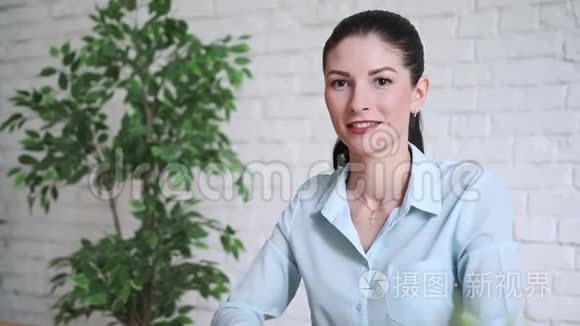 年轻的商务女性在办公桌后微笑