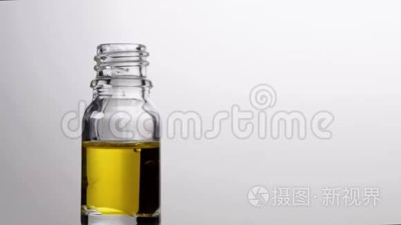 玻璃瓶与吸管精油滴在缓慢的运动。 自然疗法