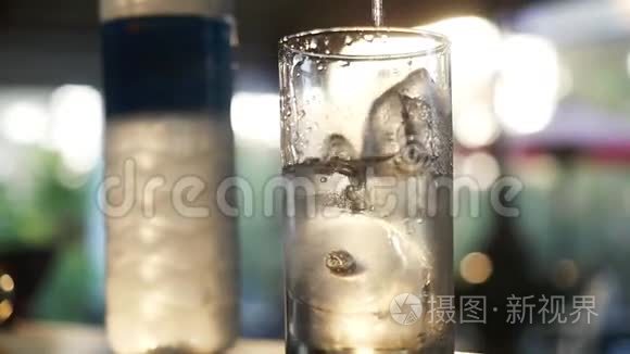 水慢慢地倒在玻璃里。 饮料中的冰块。 慢动作。 1920x1080