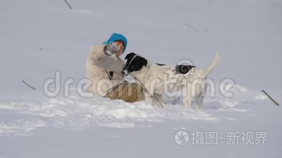 男孩少年在雪地里和狗玩得很开心。