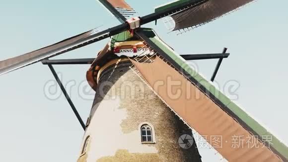 传统老风车4K低角度视图。荷兰。荷兰历史遗产。乡村农场的磨坊慢慢地旋转着。