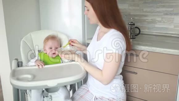 妈妈把婴儿奶酪放在一把高椅子上，用一个鹳的器具。