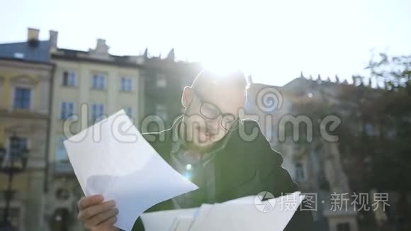 一个戴眼镜的年轻人在打电话，写文件