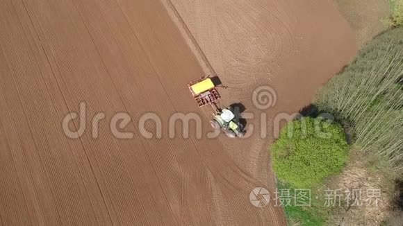 农业拖拉机在林旁春田播种，空中