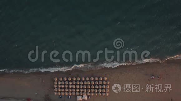 在海滩的伞下拍摄蓝色的大海和日光浴