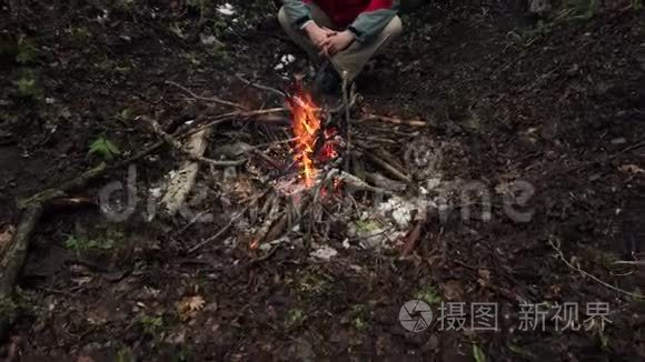 中年人坐在森林里的炉火旁视频