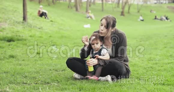 妈妈和女婴一起吹泡泡。