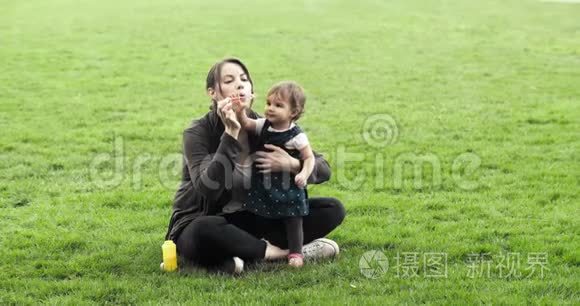 妈妈和女婴一起吹泡泡。