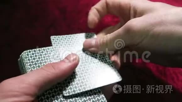 纸牌游戏。 为克雷迪递卡的人。 手和卡片特写.. 游戏在一张红色布绒桌子上。