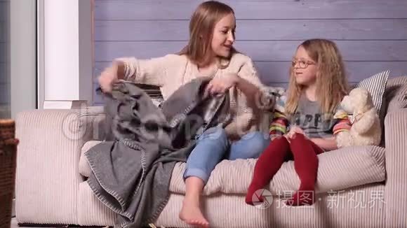 母亲和孩子在家里用毯子取暖视频