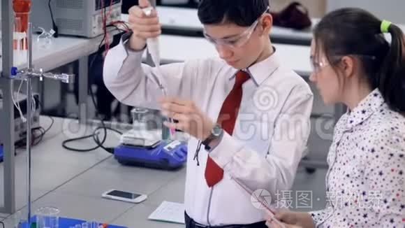 一个小学生演示如何在试管中加入化学物质。