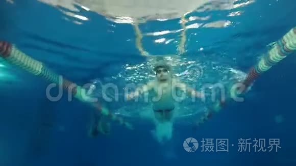 男子游泳运动员在游泳池中游泳，蝶泳在水下慢动作