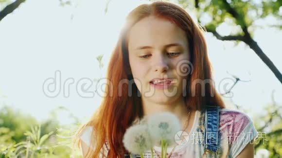 一个十几岁的女孩吹蒲公英花。 慢动作180fps视频