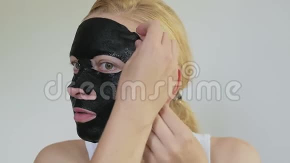 女，40岁，脸上戴着一个恢复青春活力的黑色组织面膜视频的预览图