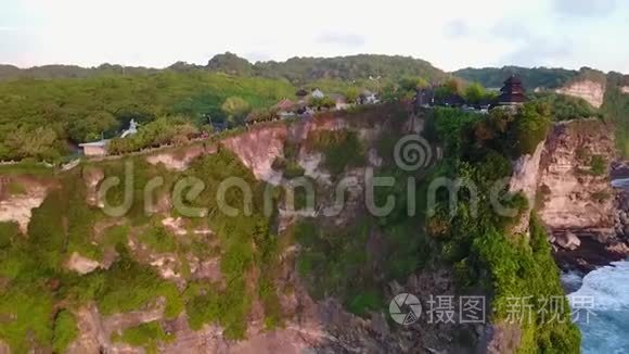 日落时分的乌卢瓦图神庙。 从空中射击。 神庙在岩石上。 美丽的自然，海洋，岩石，绿色植物。