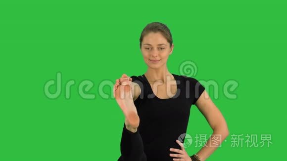 平衡和伸展的瑜伽姿势，女人在绿色屏幕上练习UtthitaHastaPadangustasana，Chroma键