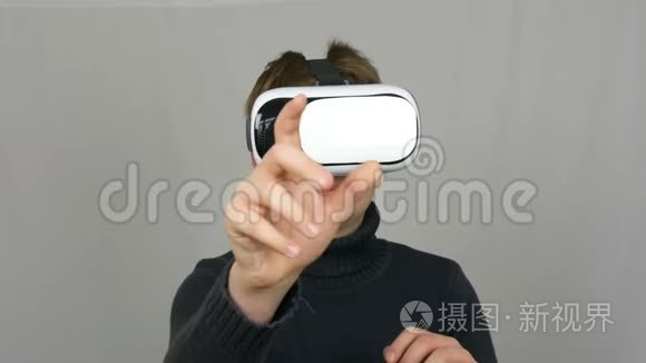 青少年男孩看白色虚拟现实眼镜或虚拟现实，并在工作室的白色背景上玩得很开心。 未来是