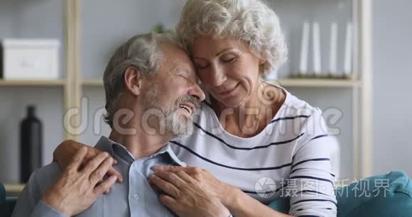 快乐的老夫妇拥抱亲密看着镜头