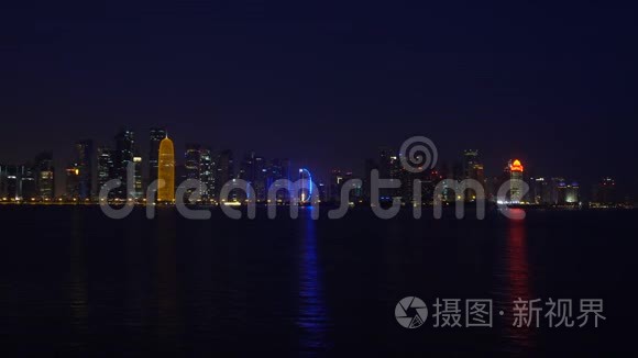 多哈夜城反映波斯湾海水，实时视频，卡塔尔，中东。 照亮了摩天大楼