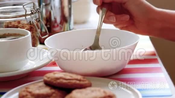 女人在吃早餐时吃麦片和牛奶