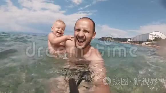 快乐的父亲和儿子一起在海滩上自拍