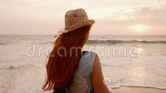 年轻的女游客在海边为日落拍照