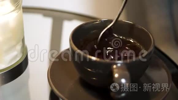 一杯被搅拌的茶。 用勺子缓慢地搅拌茶。 头上的热茶搅拌甜茶杯