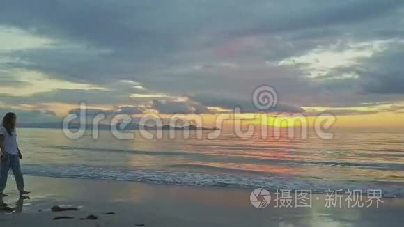 湿沙滩与海日升的瘦女孩漫步视频