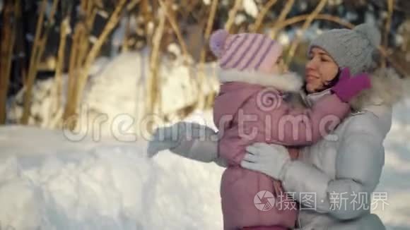 快乐的妈妈和女儿在冬天拥抱在郊区。
