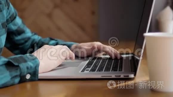 在办公室里用笔记本电脑特写男性的手，在咖啡馆旁`商人的手在笔记本键盘上打字