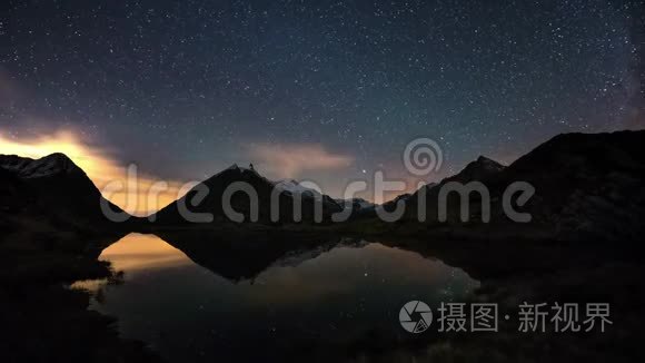 星空和猎户座时光在阿尔卑斯山上流逝，在白雪皑皑的山岭之外，在田园诗般的高山湖上倒影