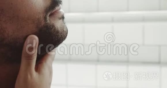 混血男人刮胡子前摸了摸他的脸和胡子