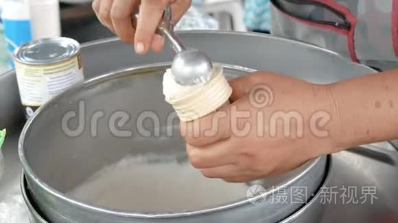 女人用勺子把冰淇淋舀到蛋筒里视频