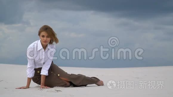 迷人的女孩坐在云间的沙滩上