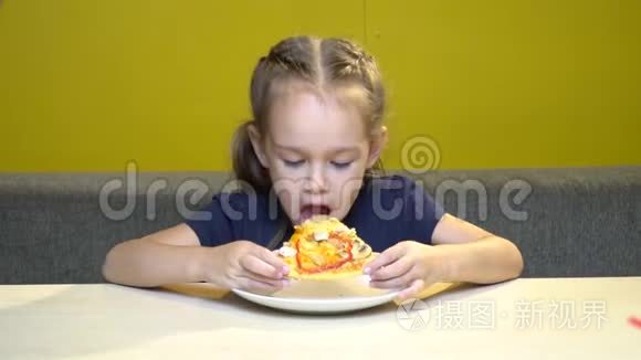 小女孩的肖像在一家有黄色墙壁的咖啡馆里吃披萨