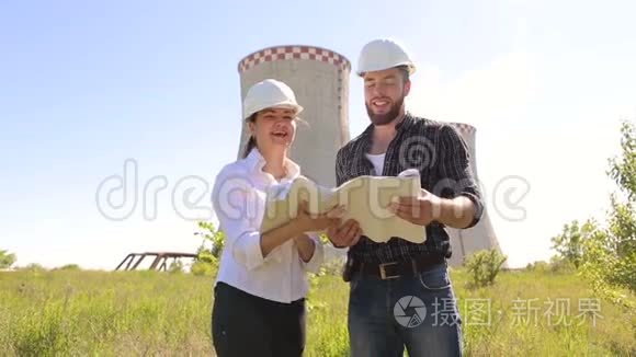 手里拿着蓝图的男女建设者。