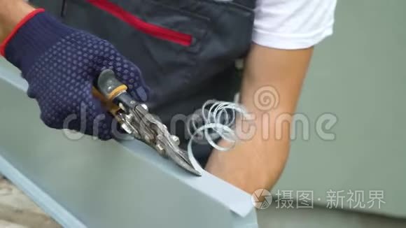 工人手戴防护手套准备PVC窗台切割金属用剪刀特写