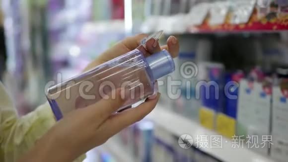 女士`手选择并购买液体卸妆液.. 一个女人选择一种乳液用于面部护理和化妆品。