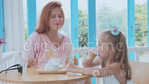 年轻的母亲和她的小女儿花时间在一家有冰淇淋的咖啡馆里