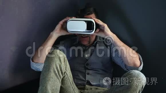 老人坐在沙发上戴着虚拟现实眼镜