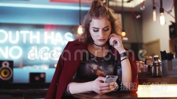 时尚时髦的女孩，红唇在一家舒适的咖啡馆里用手机©，收到信息，看起来很失望，短信回来了