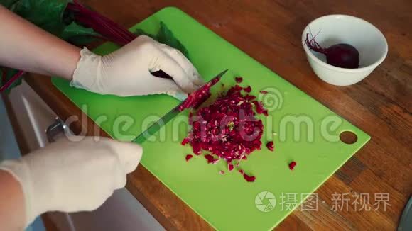 女性手在手套上的视图，切割木制桌子上的婴儿甜菜