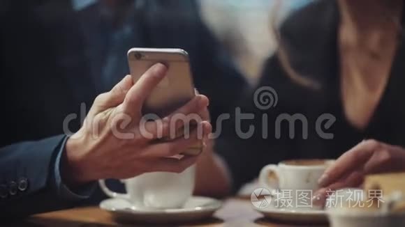 年轻夫妇在盖亚€™的智能手机上翻阅照片，讨论他们，笑着亲吻。