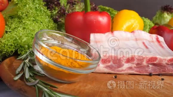 在生菜叶香料咖喱辣椒等蔬菜的背景下，不同种类的肉放在木板上
