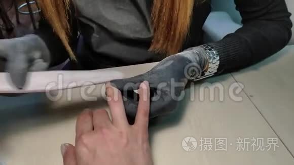 美甲师为水疗沙龙中的一位年轻女孩做硬件美甲的特写。