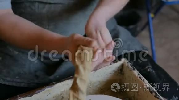 职业男陶工在陶器作坊里揉泥巴视频