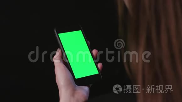 女人拿着手机用绿色屏幕放大