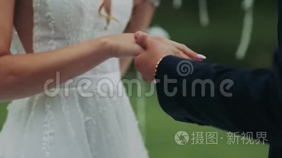 新婚夫妇在夏日阳光明媚的户外举行婚礼时戴上结婚戒指